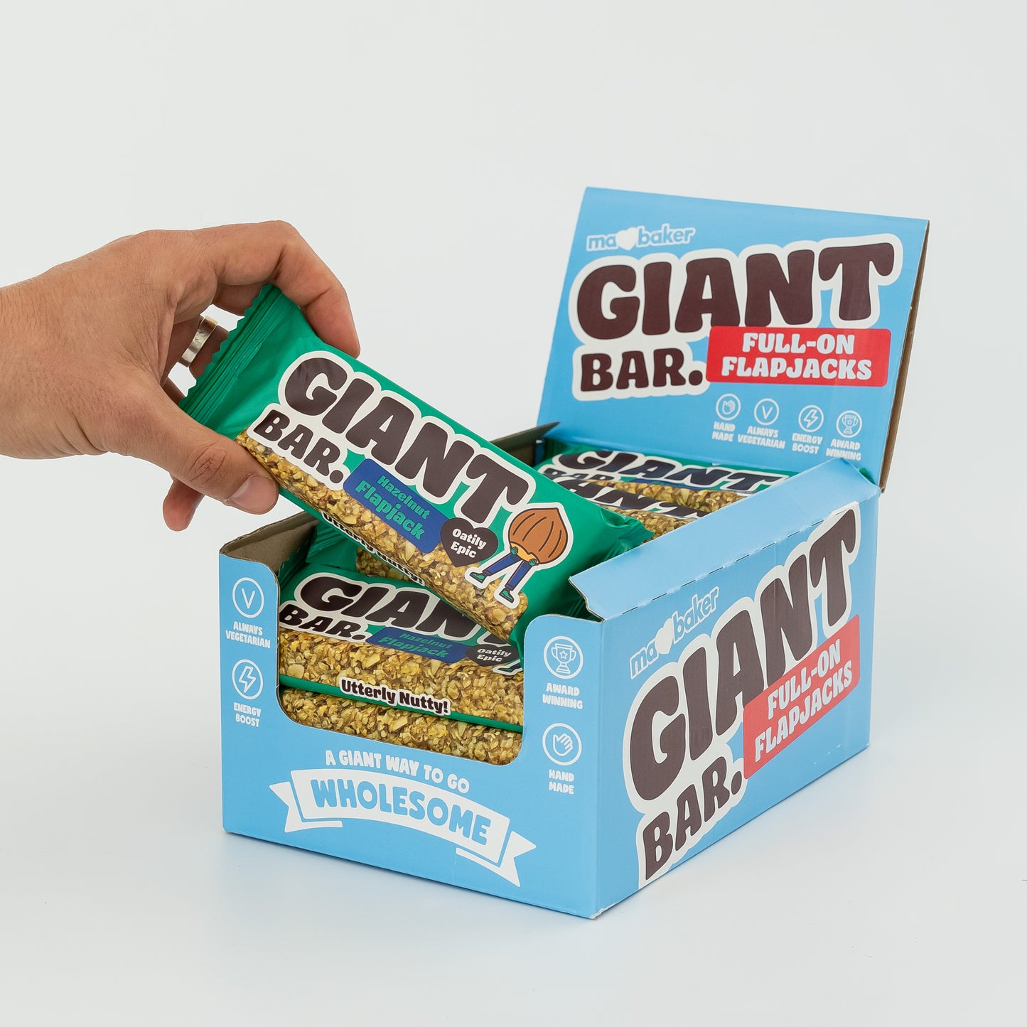 A hand taking a Hazelnut Giant Bar from a box of Giant Bars