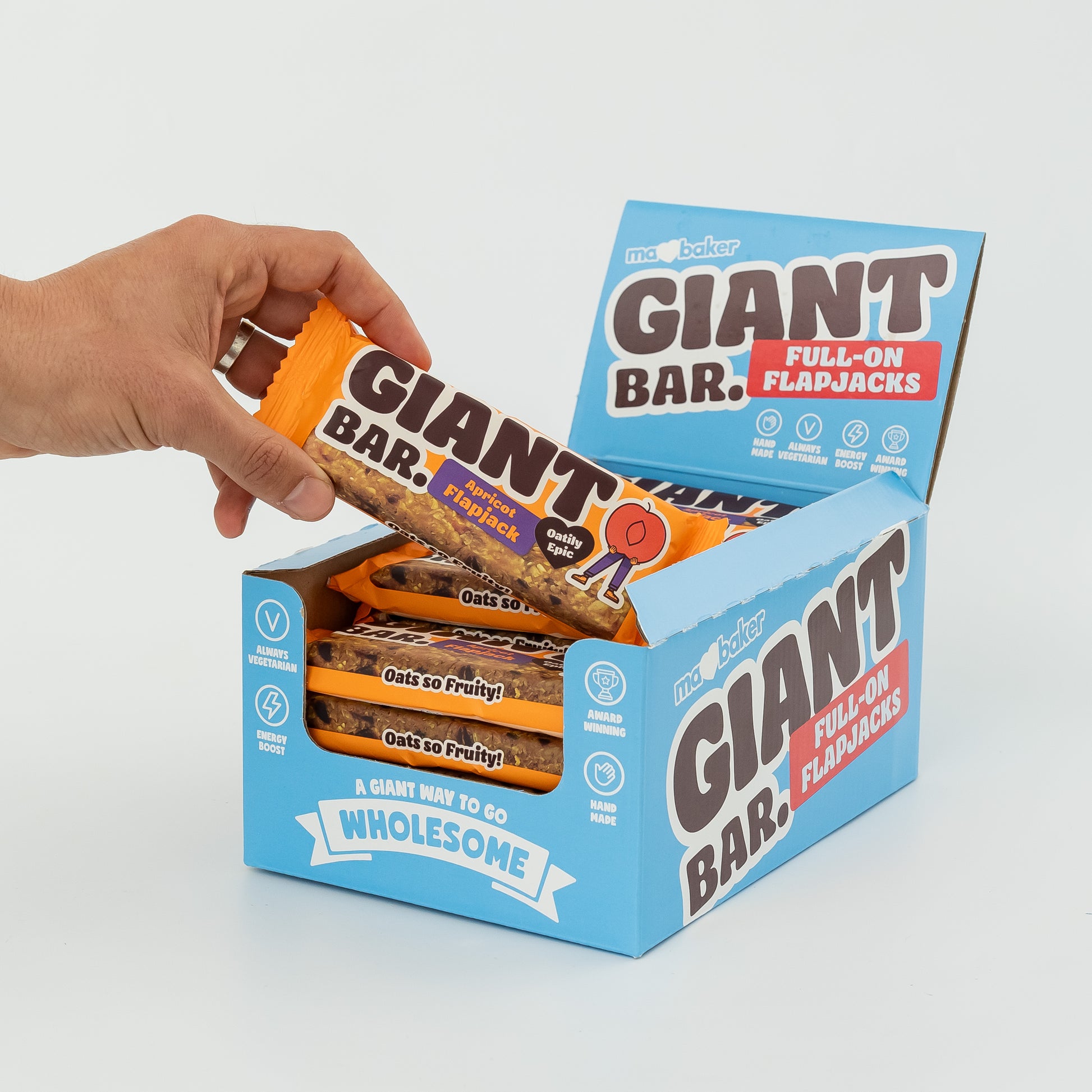 A hand taking an Apricot Giant Bar out of a box of Giant Bars