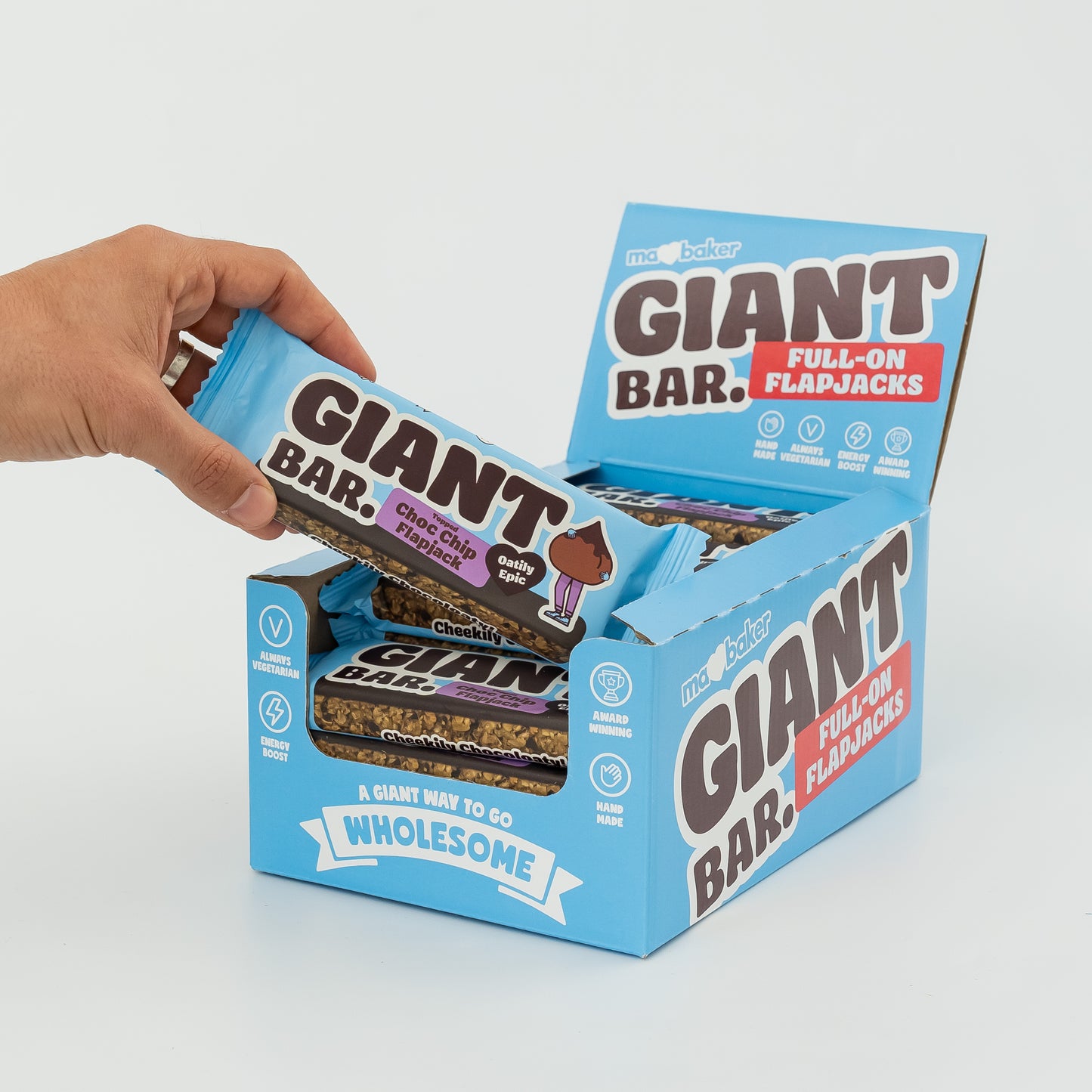 A hand taking a Topped Choc Chip Giant Bar out of a box of Giant Bars