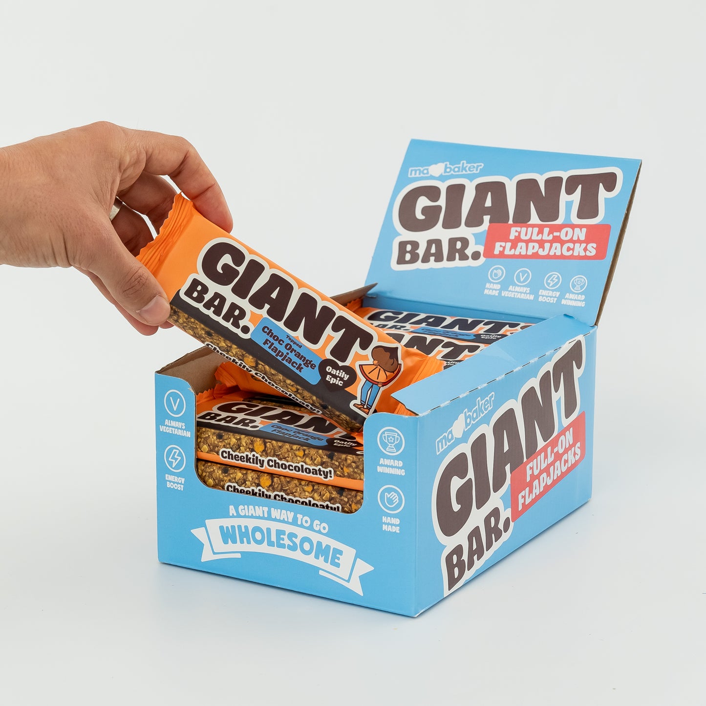 A hand taking a Topped Choc Orange Giant Bar out of a box of Giant Bars