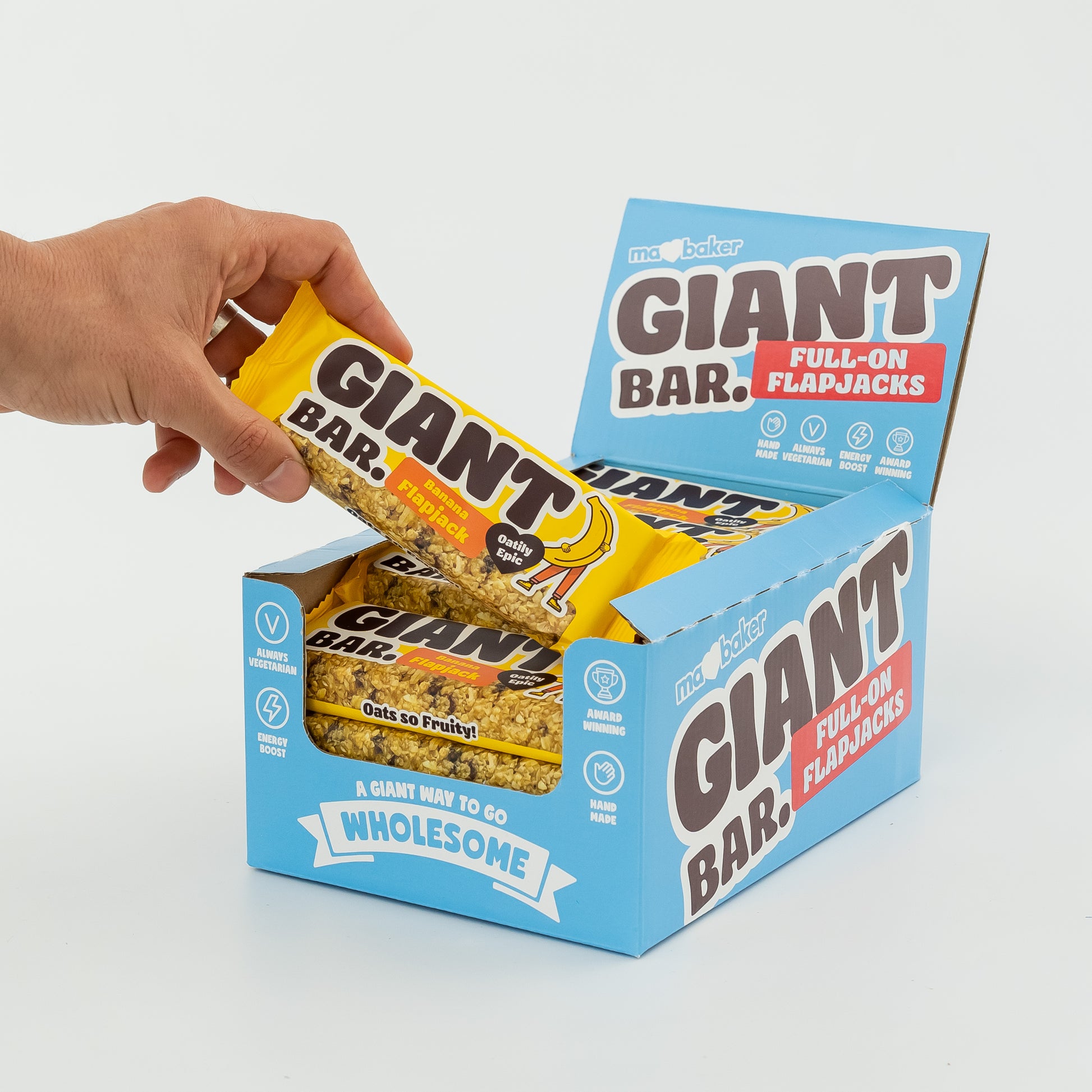 A hand taking a Banana Giant Bar out of a box of Giant Bars