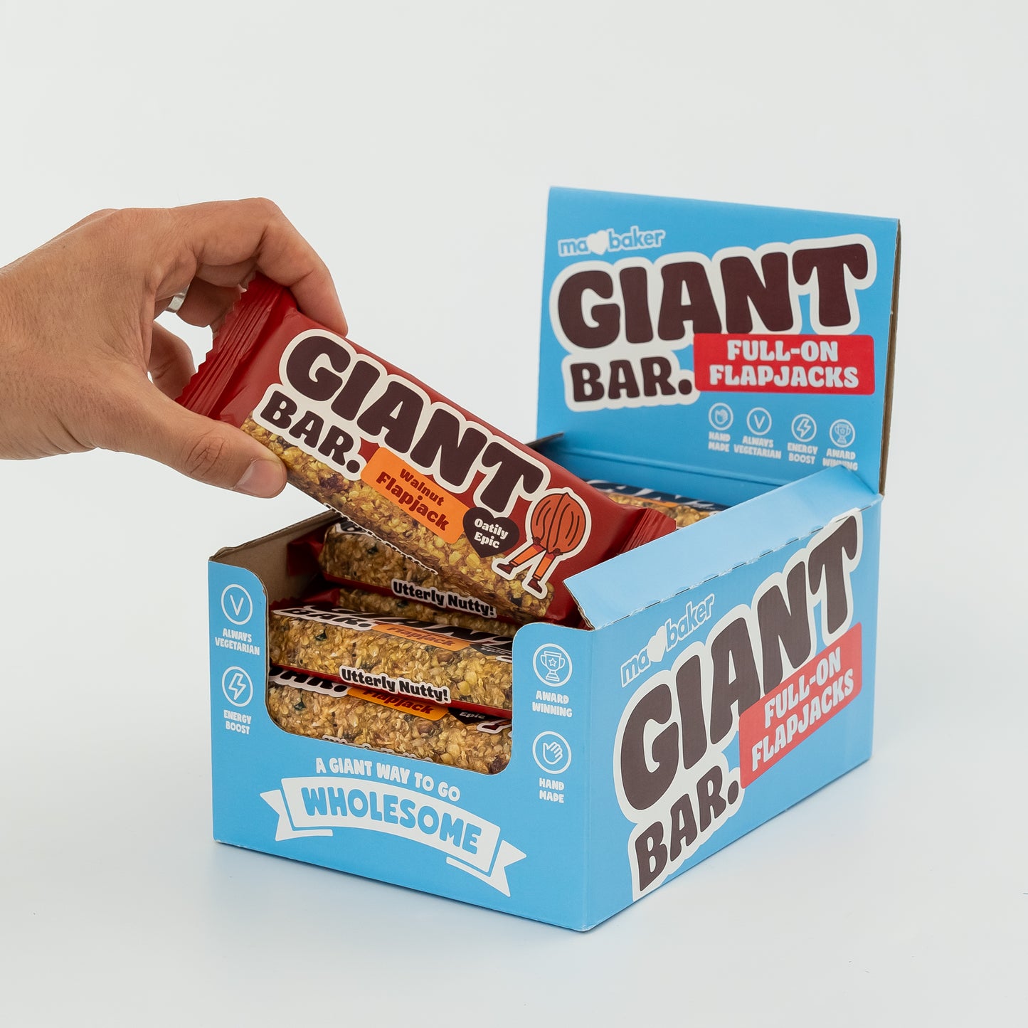 A hand taking a Walnut Giant Bar from a box of Giant Bars