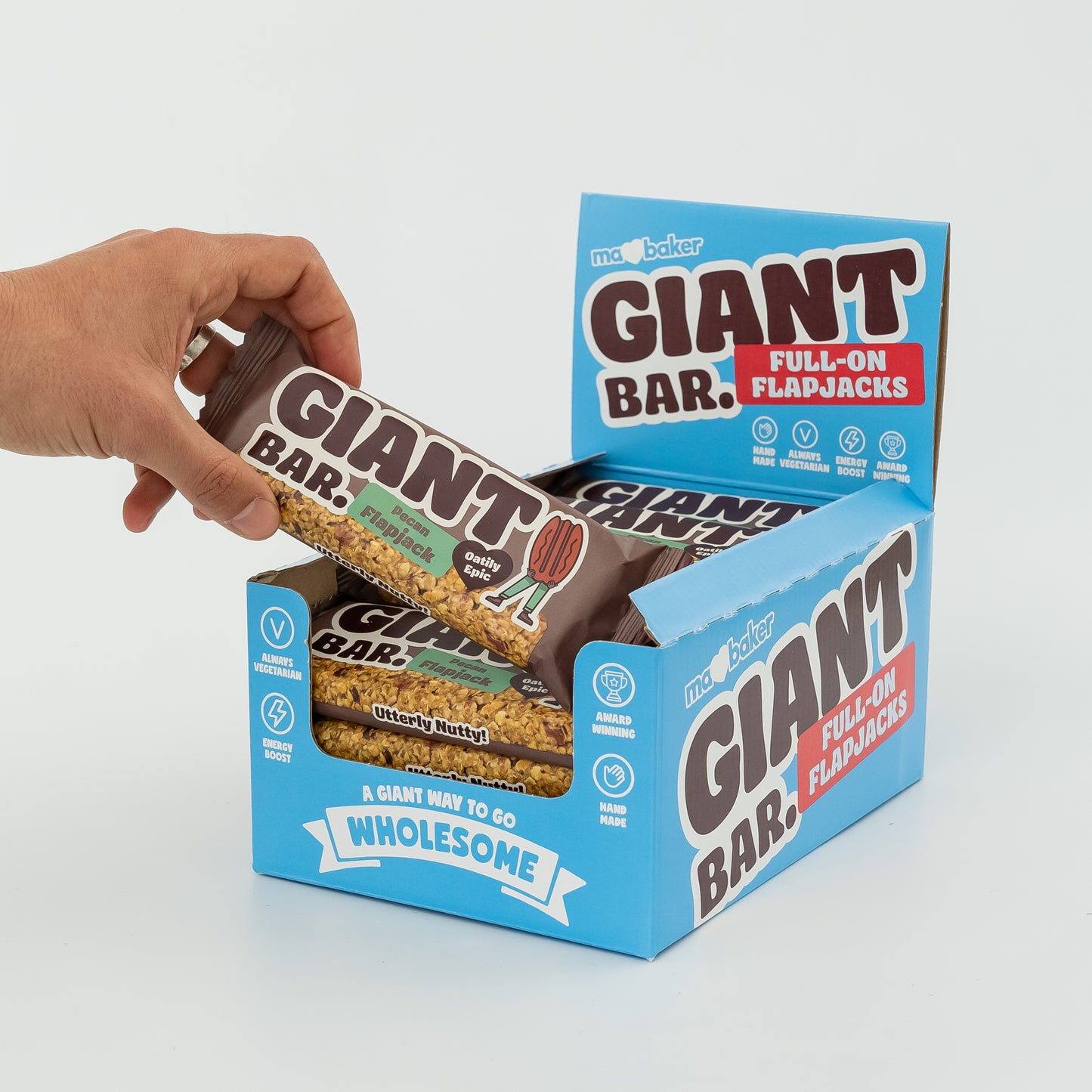 A hand taking a Pecan Giant Bar out of a box of Giant Bars