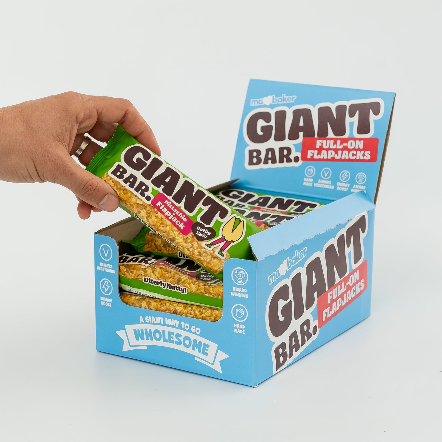 A hand taking a Pistachio Giant Bar from a box of Giant Bars